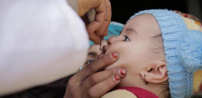 A child receives a dose of the oral polio vaccine during a nationwide immunization campaign in Amran Governate, Yemen. 
